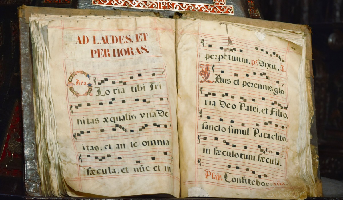 Antiguo libro códice escrito en latín con partitura musical de canto gregoriano, 
